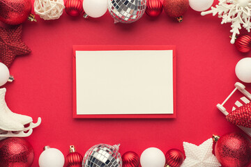 Top view photo of envelope with card white and red christmas tree decorations disco balls stars snowflake small sleigh and ice skates on isolated red background with copyspace