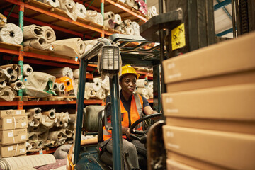 African American female forklift driver working in a textile warehouse