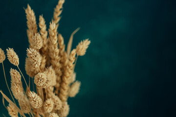 Bouquet of beautiful dried flowers on dark green blue background. Home decoration concept. Copyspace.
