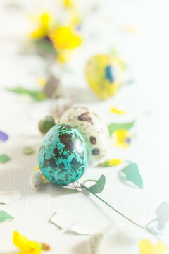 Modern Easter decor concept. Bright color quail eggs on white table