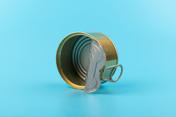 opened clean tin can with pull tab ring, bended lid and empty - isolated on blue