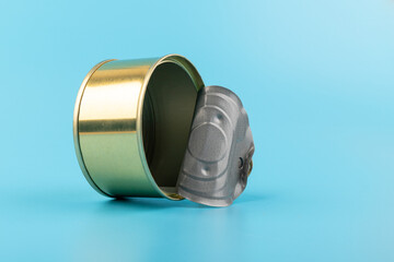 opened clean tin can with pull tab ring, bended lid and empty - isolated on blue