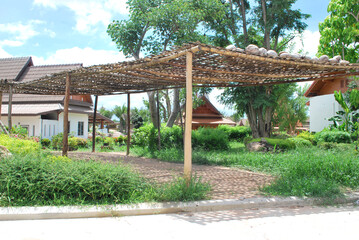 A walkway with a wooden frame in the sun. A wooden frame made of bamboo.