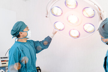 assistant surgeon preparing surgical lamps in the operating room
