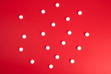 Lots of white pills on a red background. Background for text. Medicine and Pharmacology