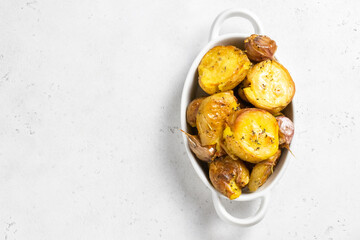 Crispy smashed baked potatoes in baking dish. Top view, copy space.