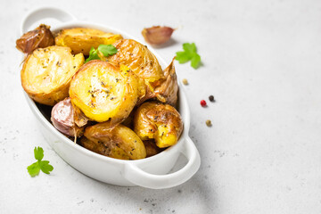 Garlic herbed roasted smashed baked potatoes in baking dish. Copy space.