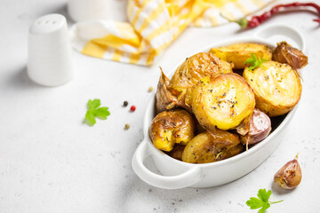 Roasted smashed baked potatoes in baking dish. Copy space.
