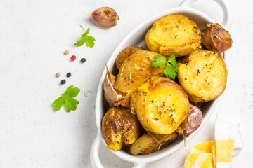 Salty herbed crispy smashed baked potatoes in baking dish. Top view, copy space.