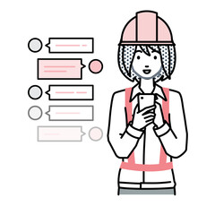 立ってスマートフォンで楽しくチャットで会話する工事現場の女性