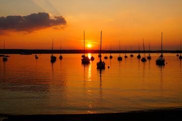 sunset at lake Ammersee in Herrsching with sailing boats resting on the water on a warm August night (Bavaria, Germany)	