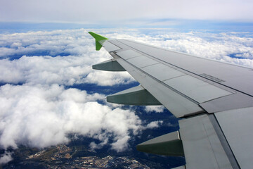 Fototapeta na wymiar The plane is flying in the cloudy sky