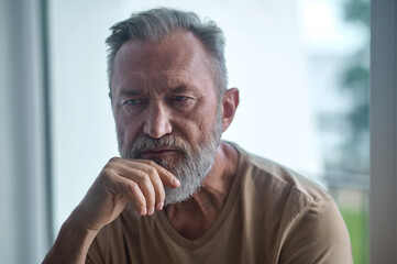 Thoughtful lonely man sitting in a room