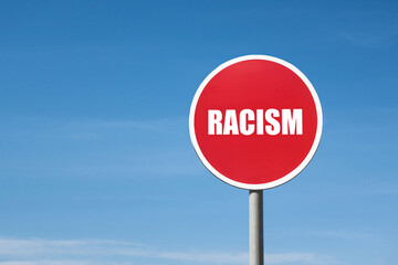 Word 'racism' in a round red frame against a blue sky