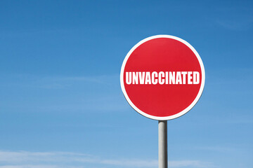 'Unvaccinated' sign in a round red frame against a blue sky