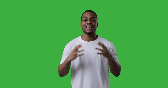 African american man explaining and giving thumbs up gesture over green background