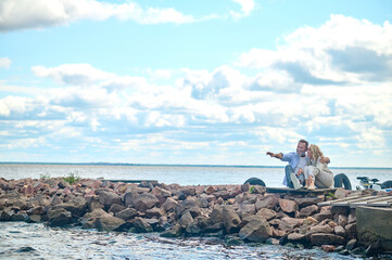 Happy mature couple sitting by sea