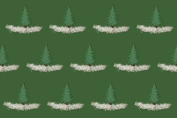 Christmas pattern concept made of green toy Christmas tree, fake snow flakes on green background. Minimal New Year holiday idea. Creative top view wallpaper.