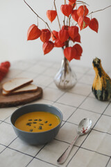 Hot healthy vegetarian pumpkin cream soup with seeds on the table