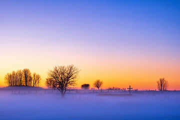 Fototapeta na wymiar Sunset with fog at a old church ruin in winter