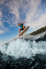amazing view of man flying in the air on wakesurf over splashing wave