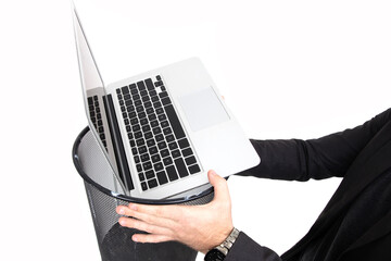 Close-up of a laptop in the trash. Professional burnout at work