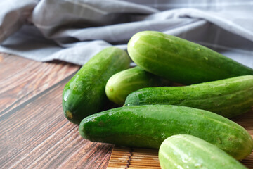 Green cucumber with wooden texture background