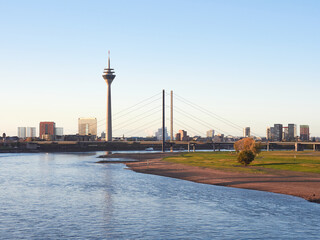 Fototapeta premium Panorama view of the city of Dusseldorf from the Rhine in Germany. City skyline with the famous tower and bridge at sunrise.