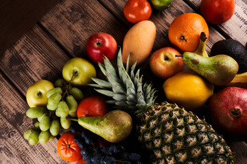 Mix of fresh juicy colorful exotic tropical fruits on wooden background top view