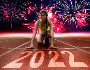 2022 New Year celebration - Racing lane with young female athlete at starting block under fireworks - obrazy, fototapety, plakaty