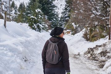 Mujer caminando por bosque invernal