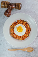 Korean food kimchi fried rice dish with fried egg on white plate