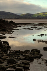 British countryside view from a beach with rocks and shallow focus reflections