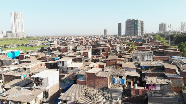 An aerial drone movement shot of the closely packed urban slums or shanty town housing situated in suburban part of the Mumbai city
