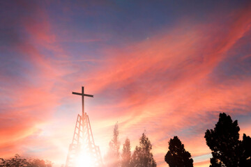 cross religion symbol silhouette in Iron tower over sunset sky background