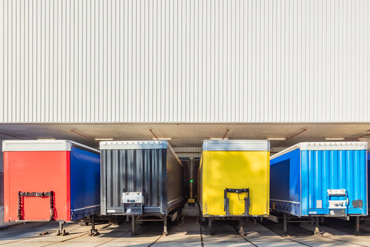 Colorful truck trailers in front of the loading dock of a Dutch warehouse