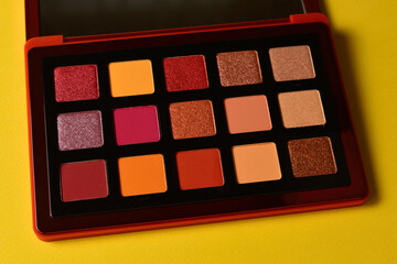 Eye shadow palette on orange background. Copy space.