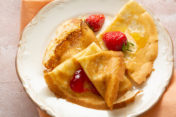 Close up of crepes with strawberry jam on plate breakfast food