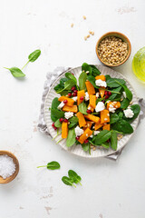 Roasted pumpkin and feta salad top view winter food on light surface