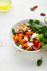 Close up Butternut pumpkin salad with feta and roasted chickpea healthy food on light surface