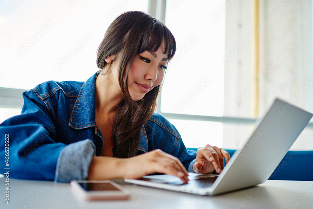 Poster young asian woman using laptop computer and 4g internet connection for searching web page in social 
