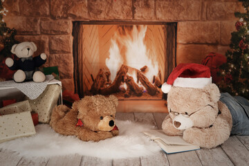 Teddybär liest vor einem Kamin ein Buch - Weihnachten