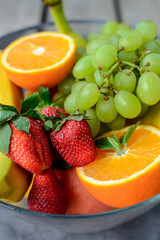 Various fruits and berries on dark stone table
