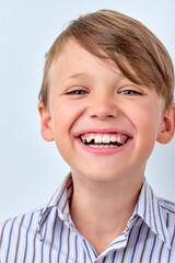 Attractive caucasian child boy with perfect toothy smile and clean skin cute face smiling laughing posing at camera isolated in studio on white background. human emotions, childhood concept.