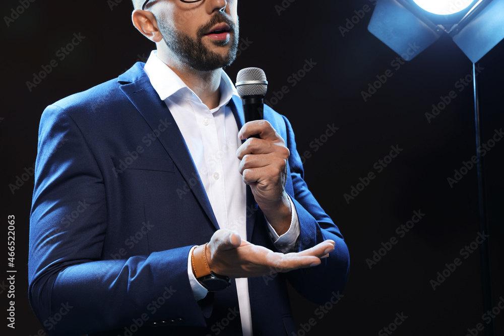 Wall mural motivational speaker with microphone performing on stage, closeup. space for text