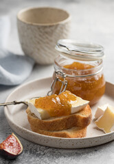 Bruschetta with brie cheese and fig jam on ceramic plate. French cuisine. vertical image
