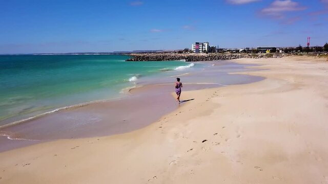 Woman Running on Beach in Australia