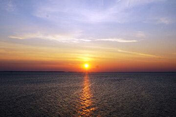 Sunset over the water with a glittering path.