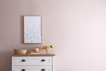 Beautiful bouquet, books and decor on chest of drawers near beige wall indoors, space for text. Interior design