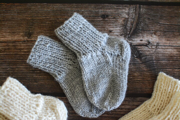Fototapeta na wymiar Chunky and warm handmade woolen socks on dark wooden background 